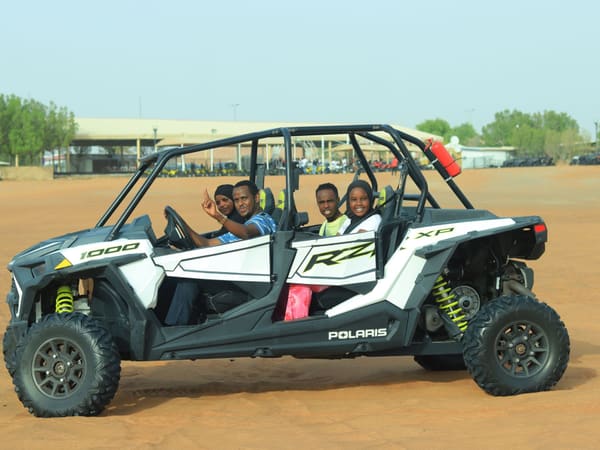 Group enjoying a buggy ride through dunes on an excursion