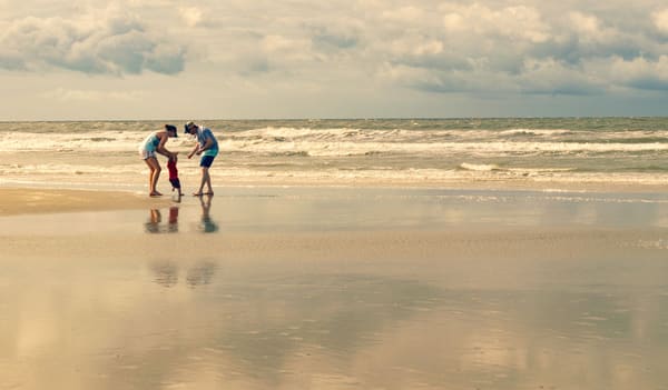 Family playing together in shallow water near the beach