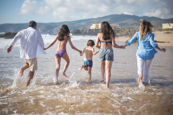 Family having fun together on the beach shore